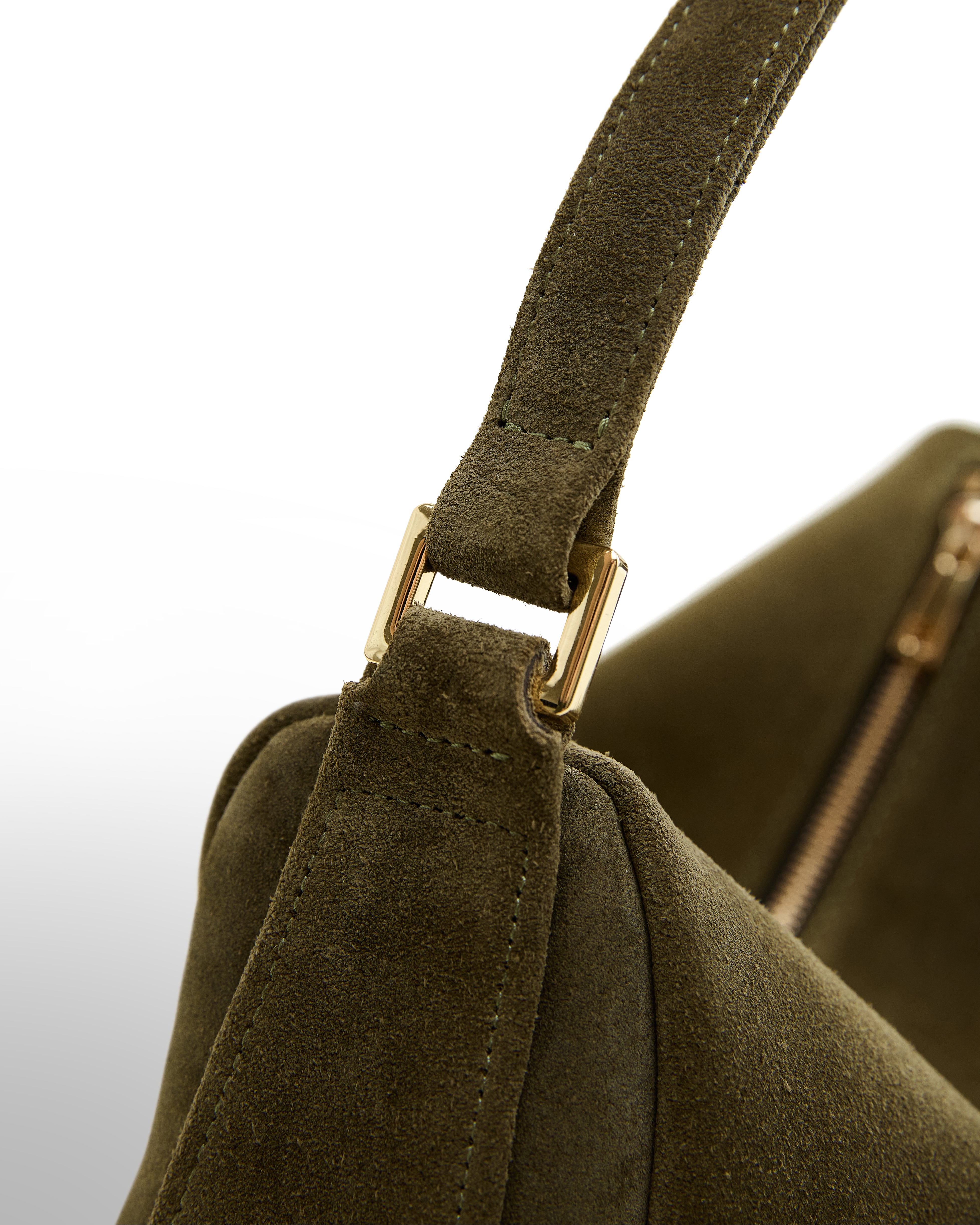 Close-up detail of Poelle Atelier luxury olive suede handbag strap and gold hardware