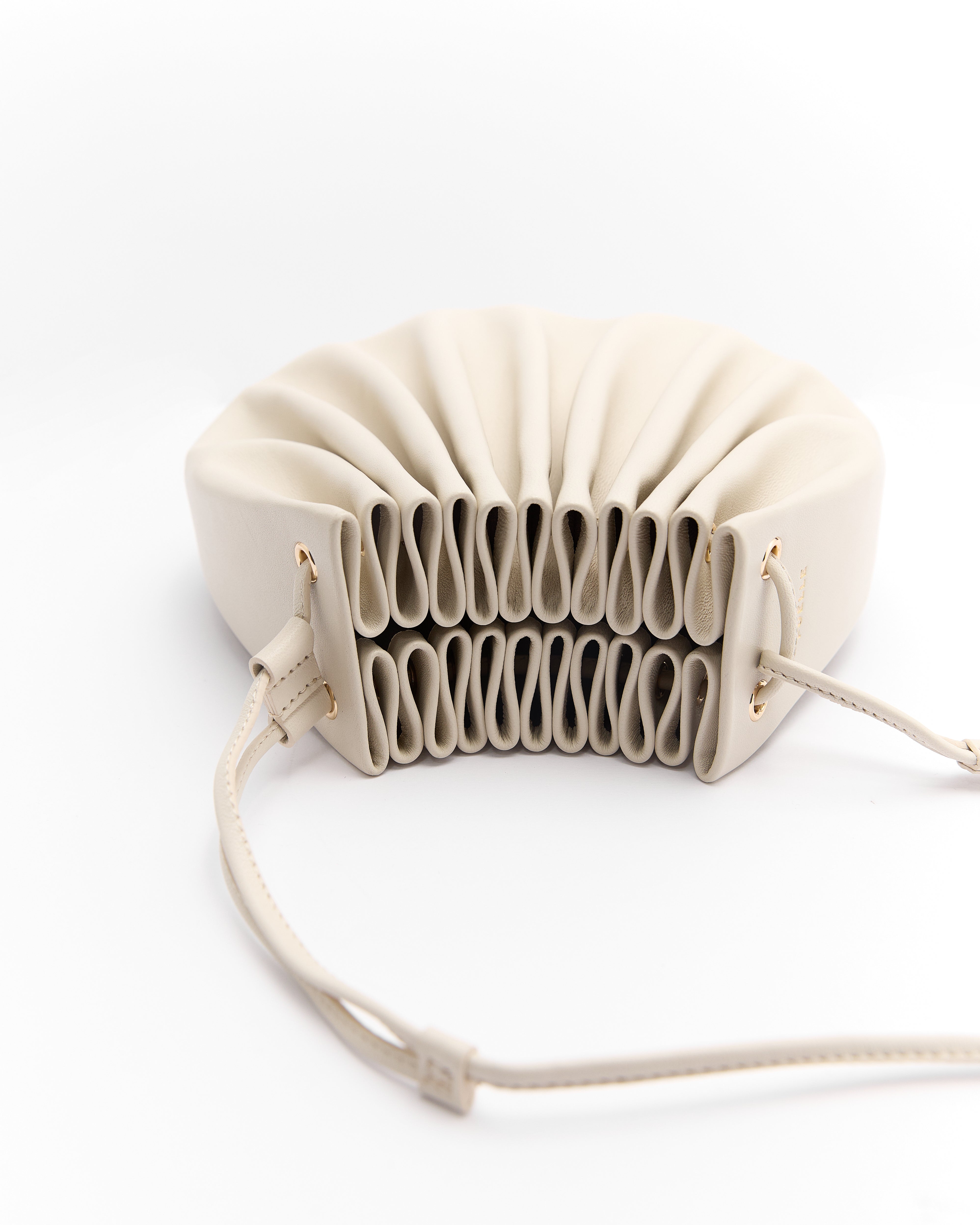 Poelle Atelier luxury summer crossbody bag in light beige with pleated design and adjustable strap