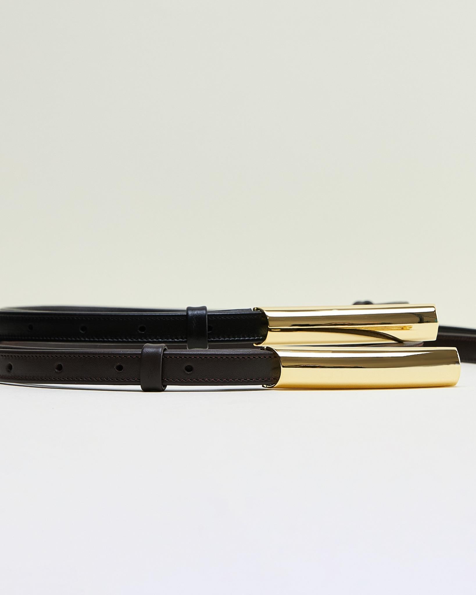 Minimalist belt for women in black leather with sleek gold rectangular buckle by Poelle Atelier