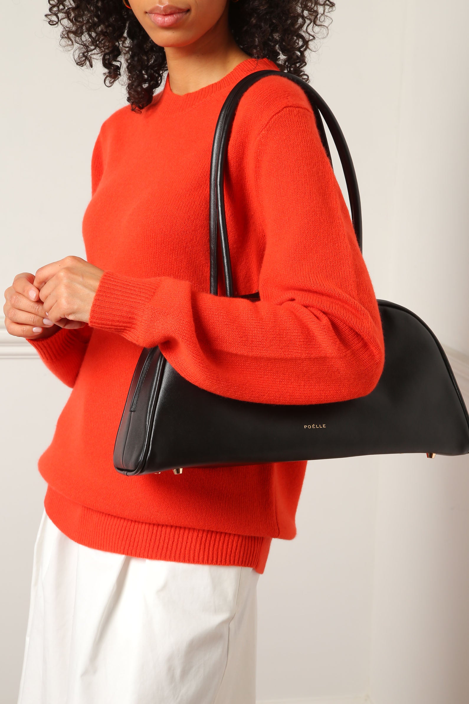 Poelle Atelier black leather east-west horizontal bags worn on shoulder with curved design