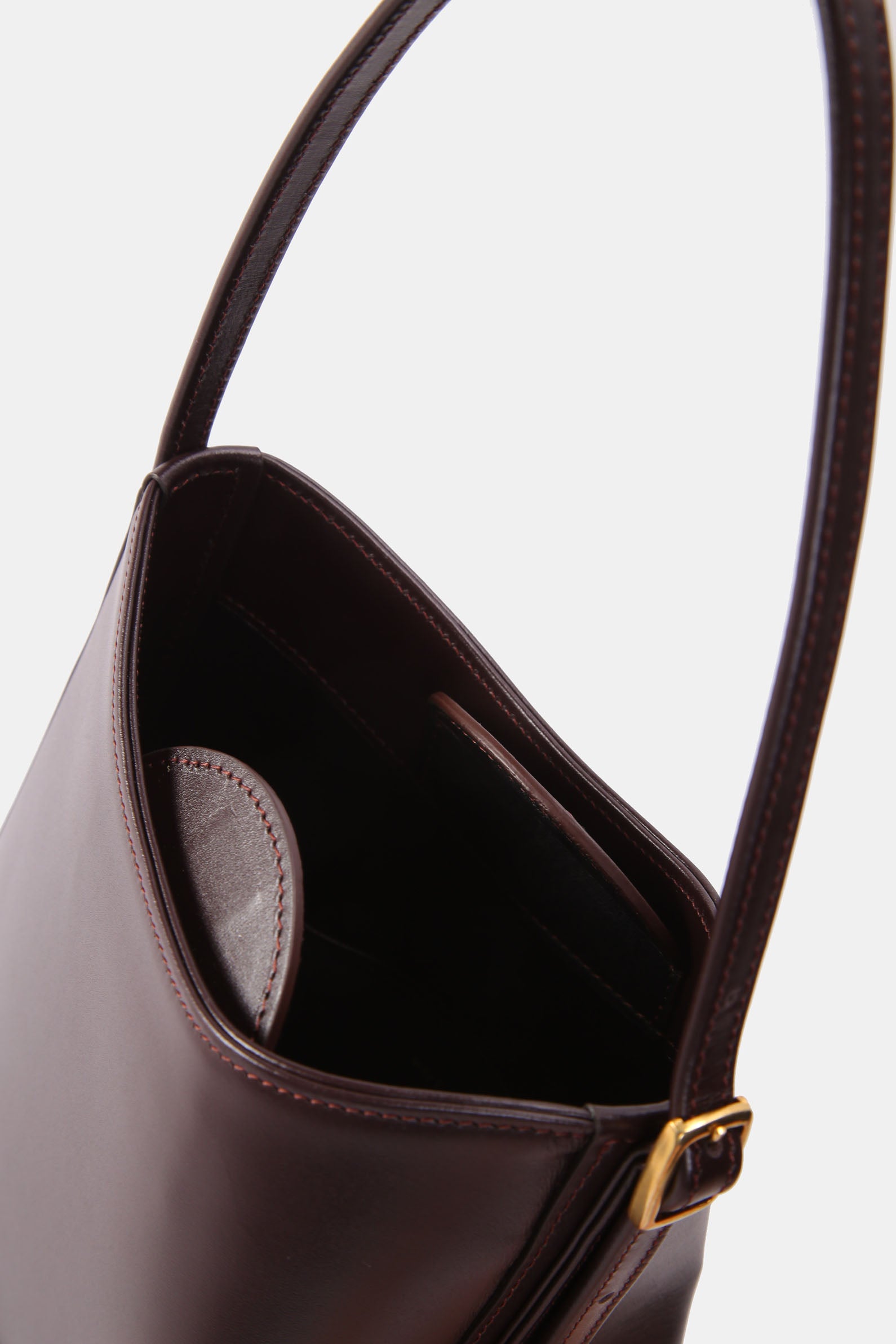 Poelle Atelier luxury minimalist leather bag in dark brown with adjustable strap and smooth finish