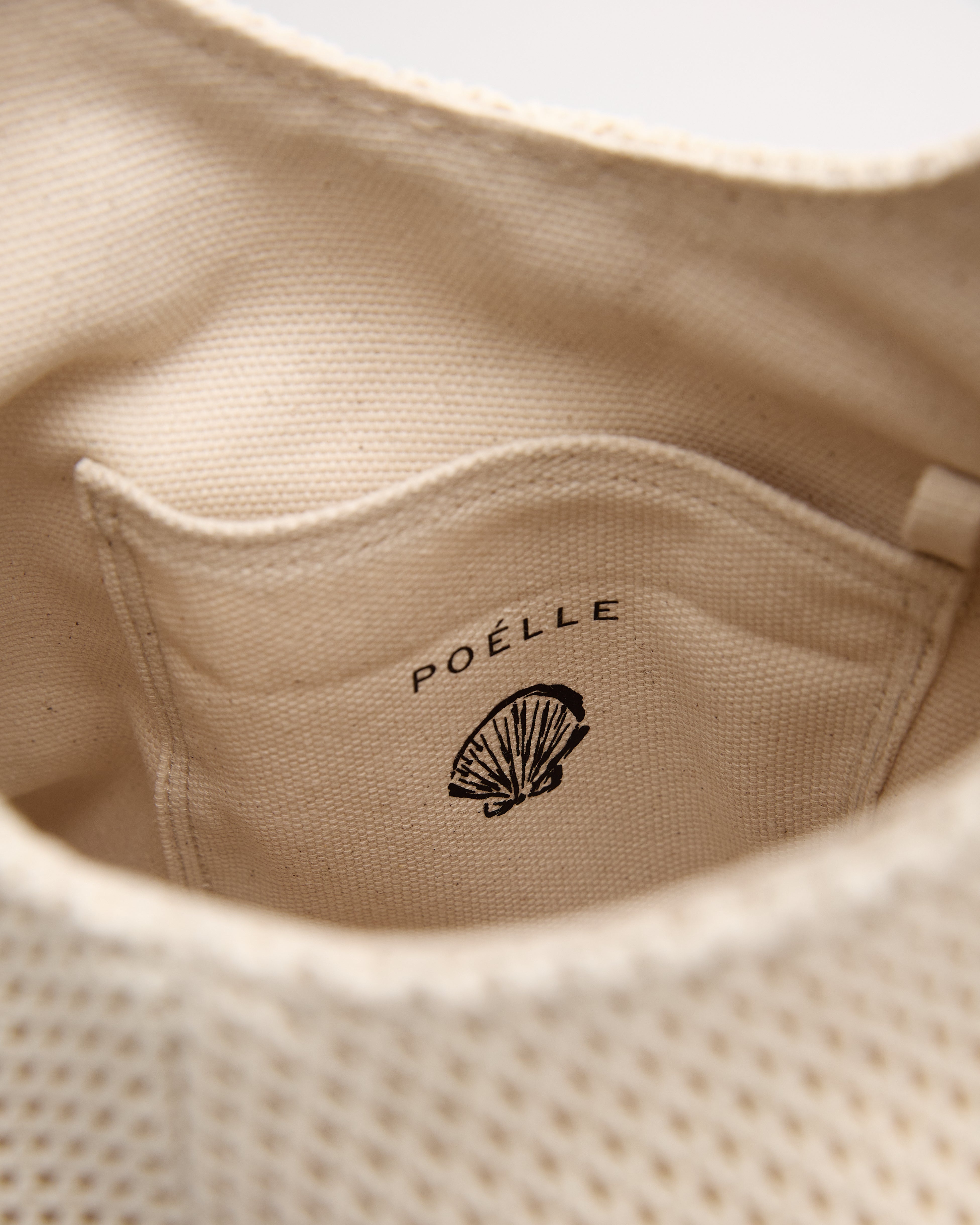 Interior close-up of Poelle Atelier luxury minimalist summer bag showing fabric pocket and logo detail