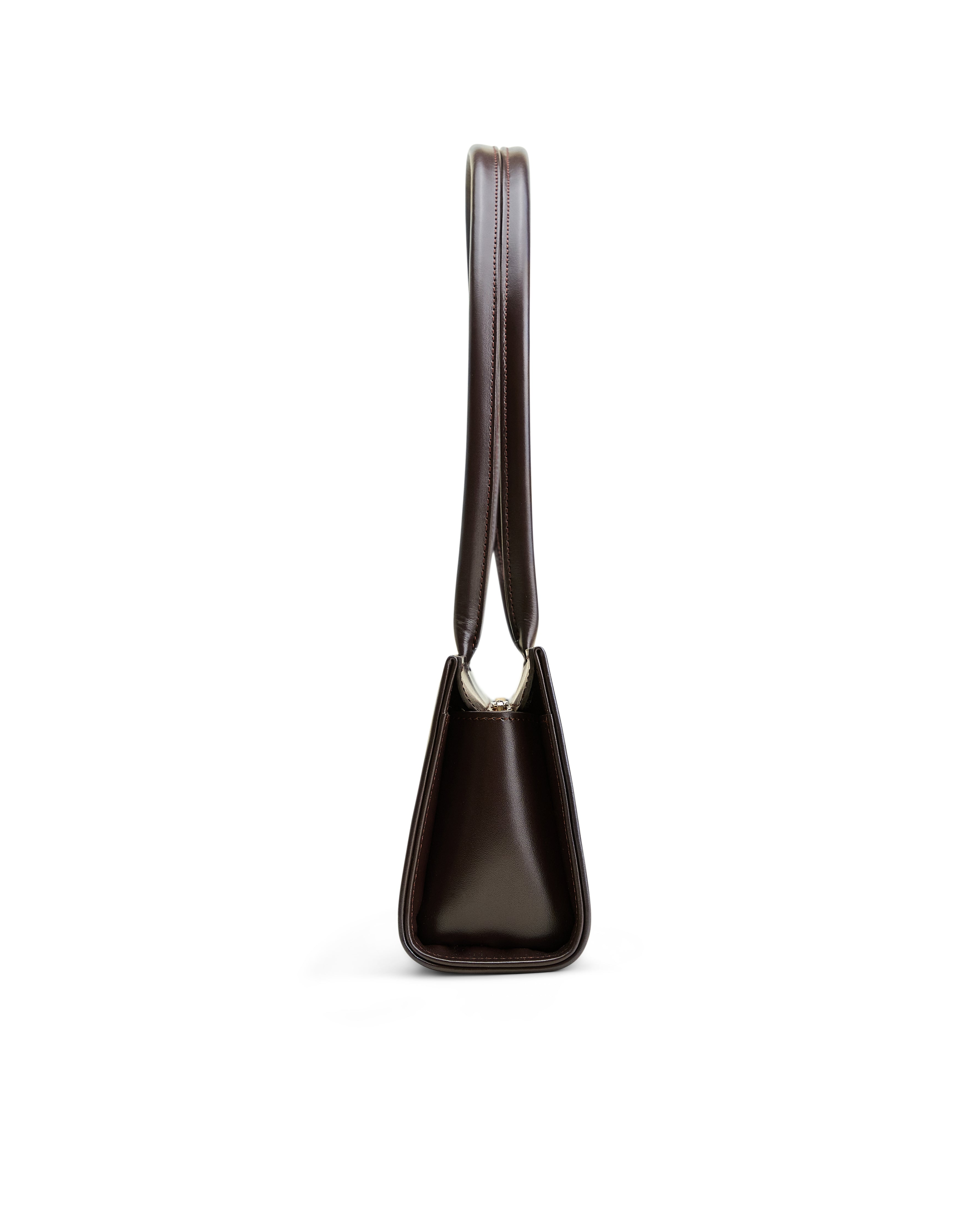 Side view of Poelle Atelier brown leather handbag with sleek design and sturdy strap