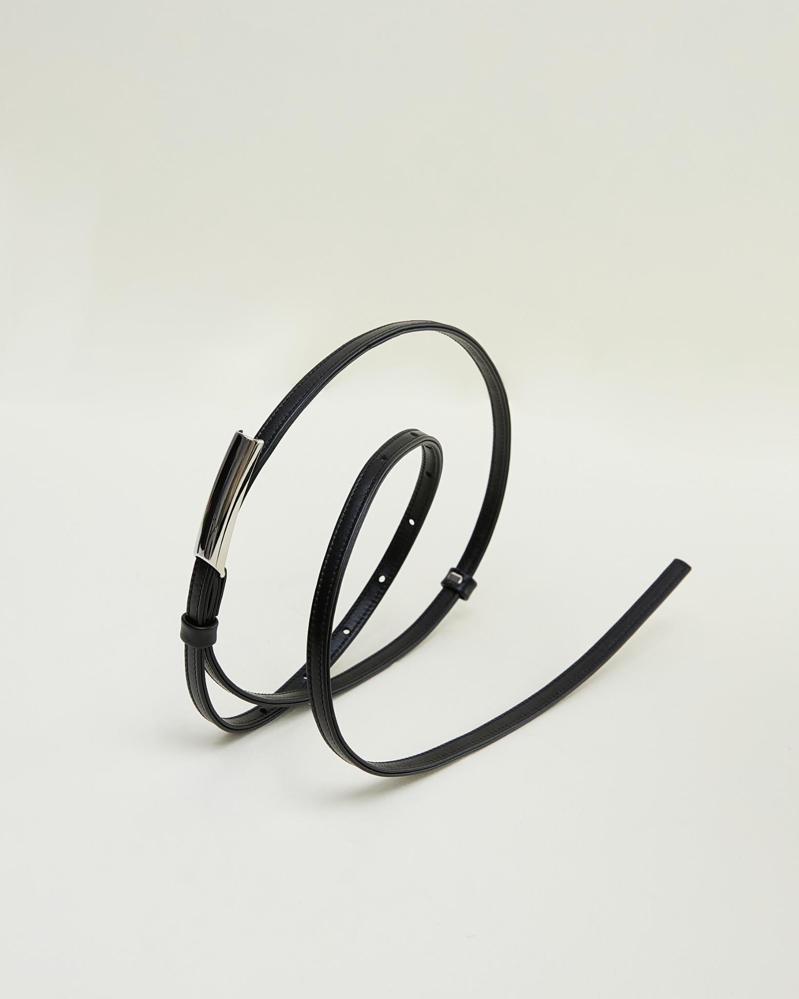 Minimalist brown leather belt by Poelle Atelier displayed on white background