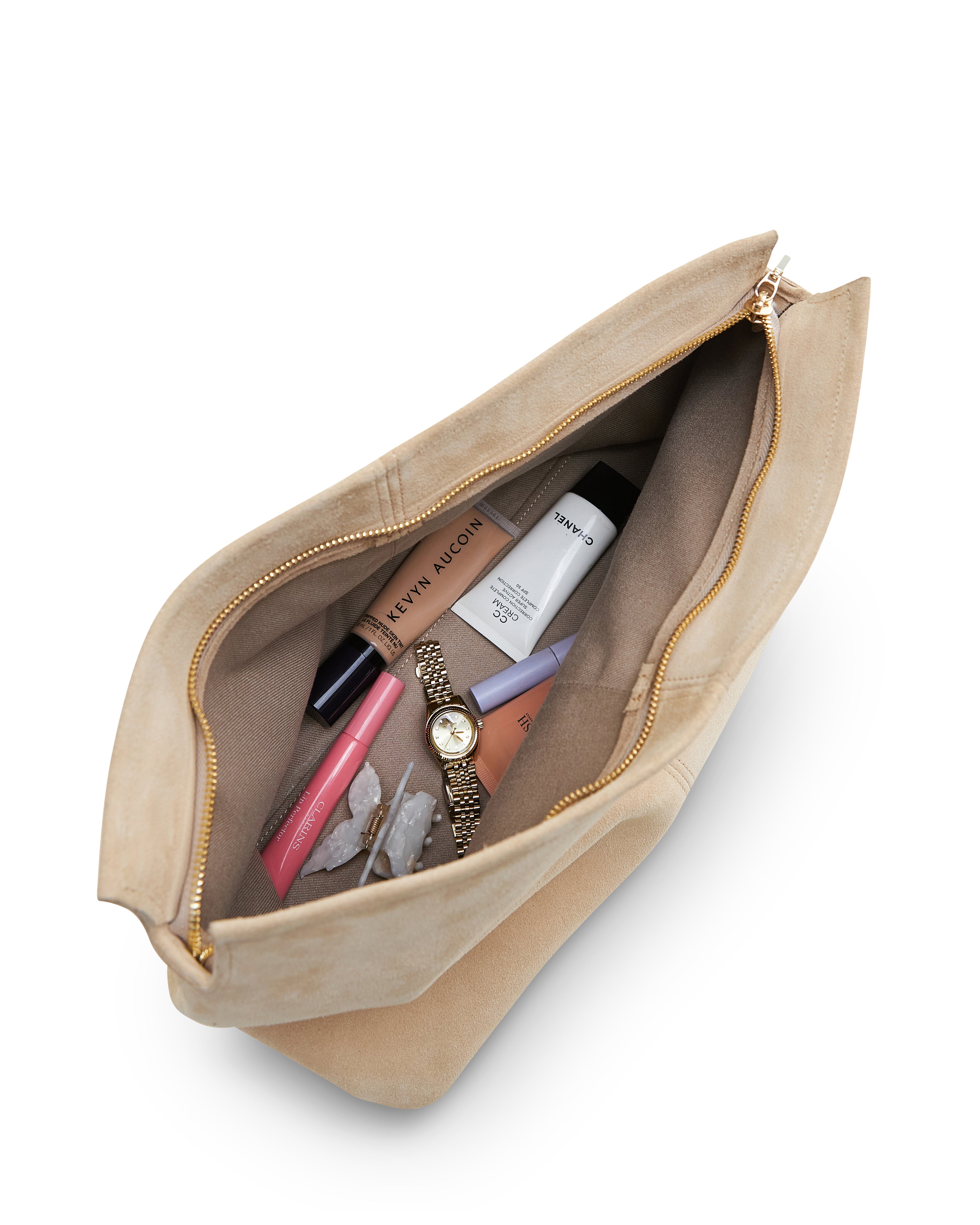 Beige luxury suede clutch bag by Poelle Atelier open showing makeup and accessories inside
