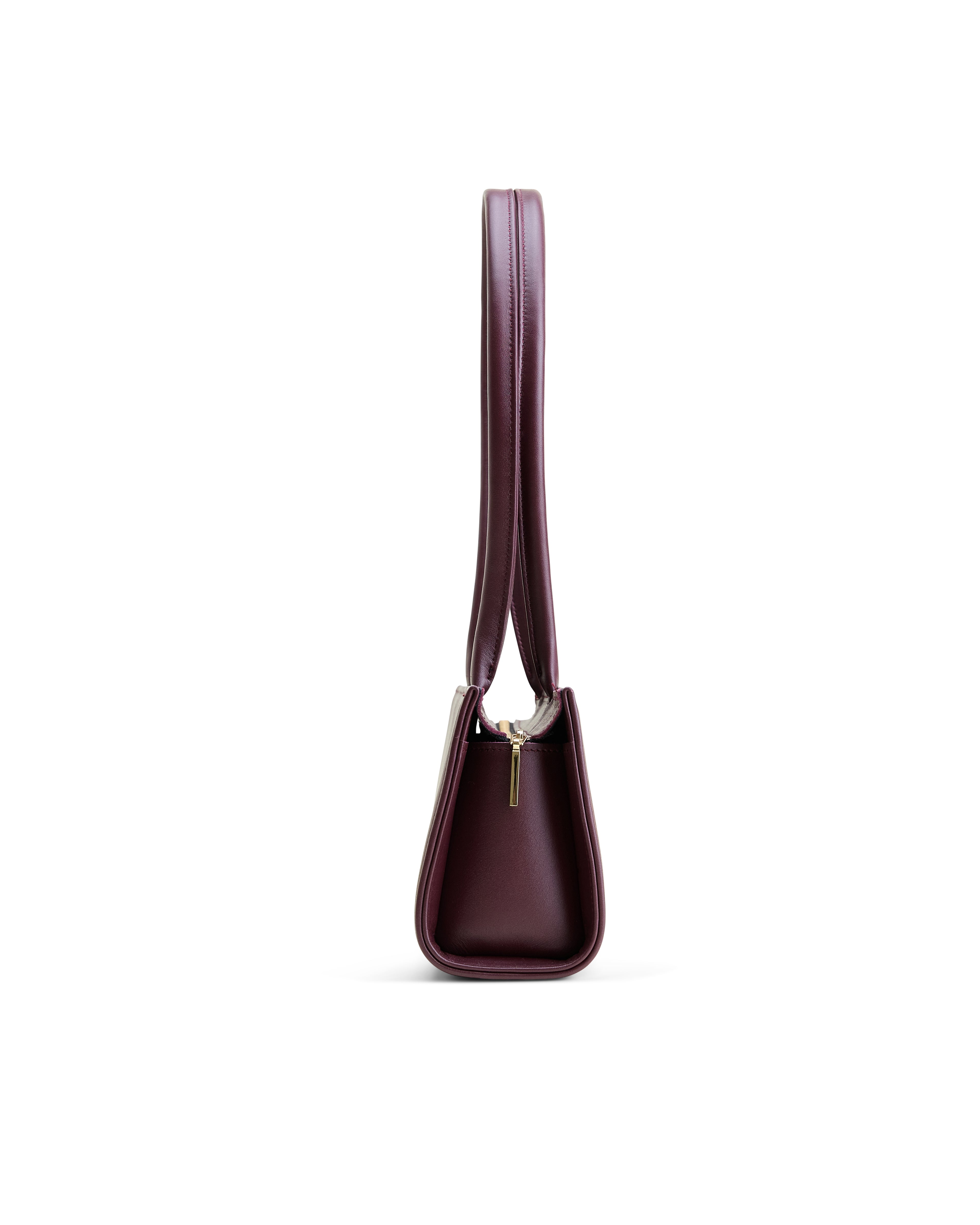 Poelle Atelier burgundy east-west horizontal leather bag side view with slim strap and zipper detail