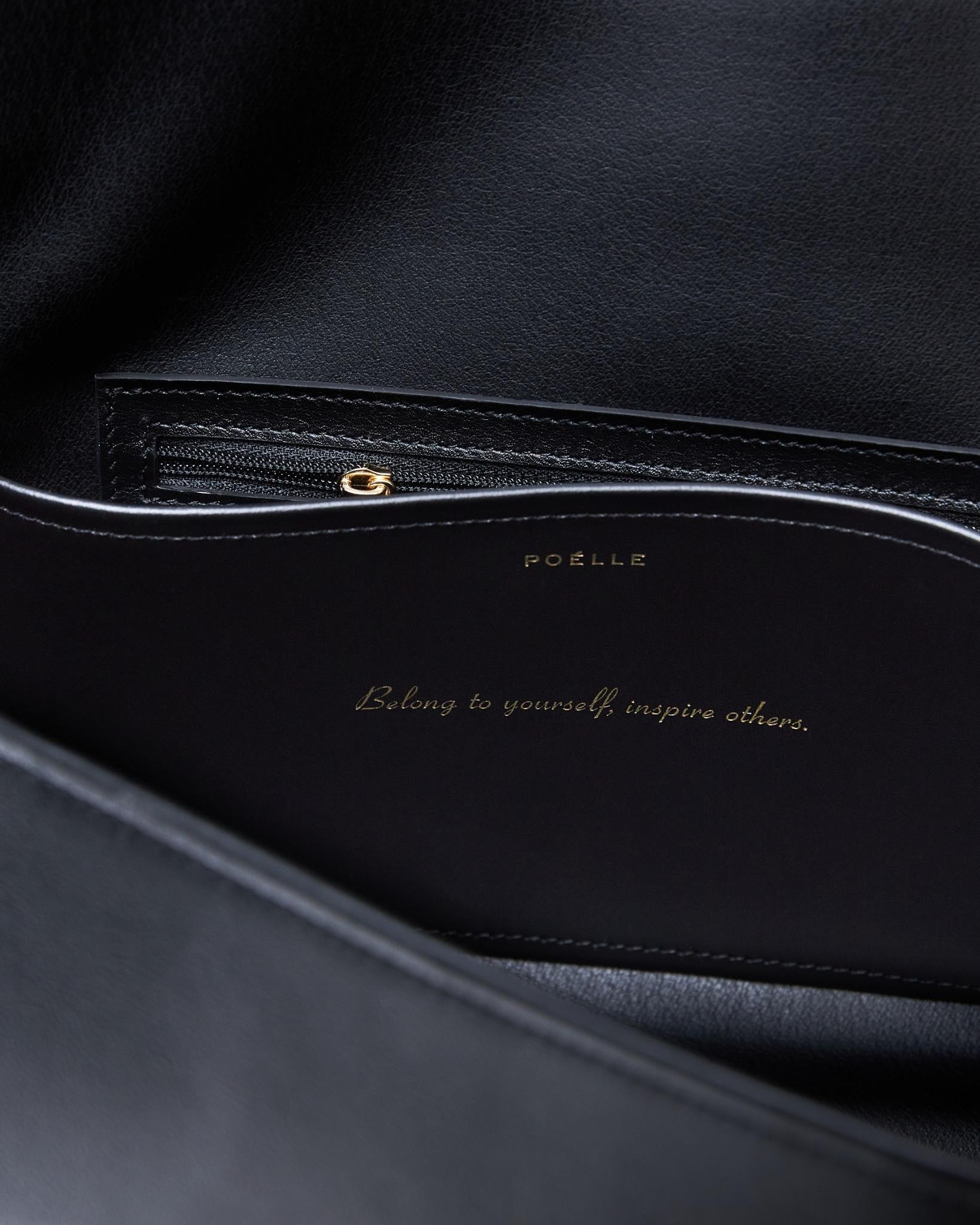 Interior view of Poelle Atelier high-end fashion leather bag showing black leather and zipper pocket