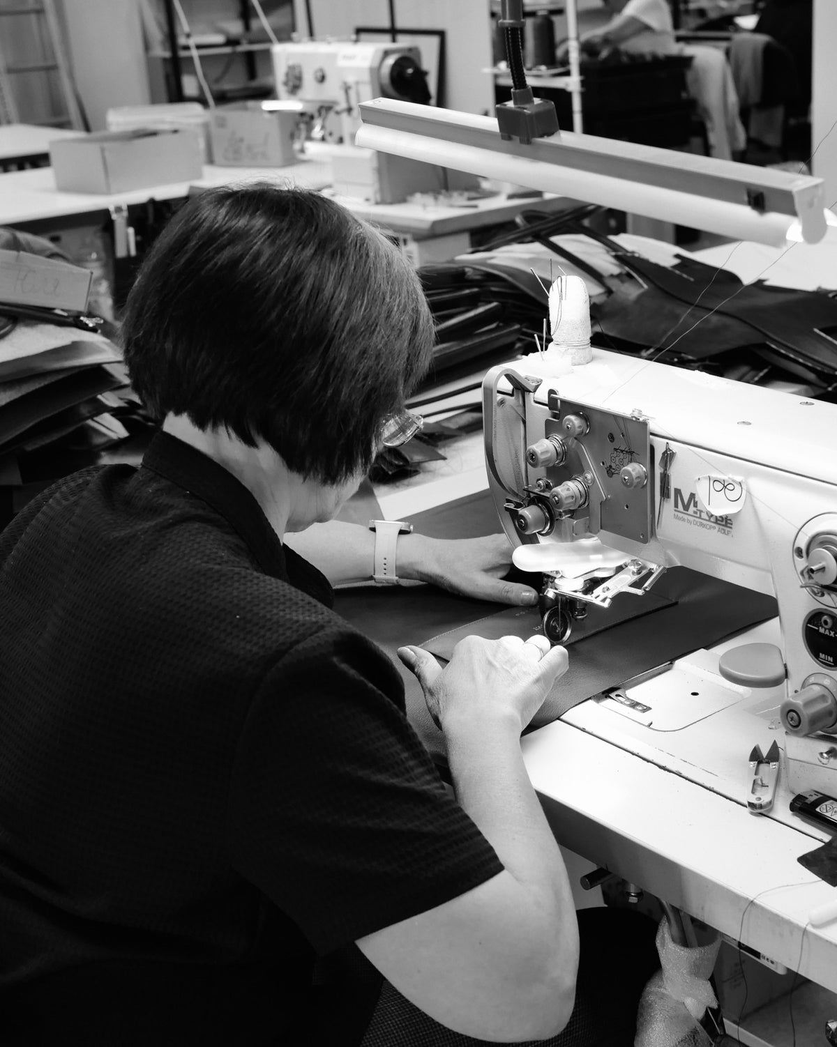 A seamstress at her sewing machine in the Poelle atelier