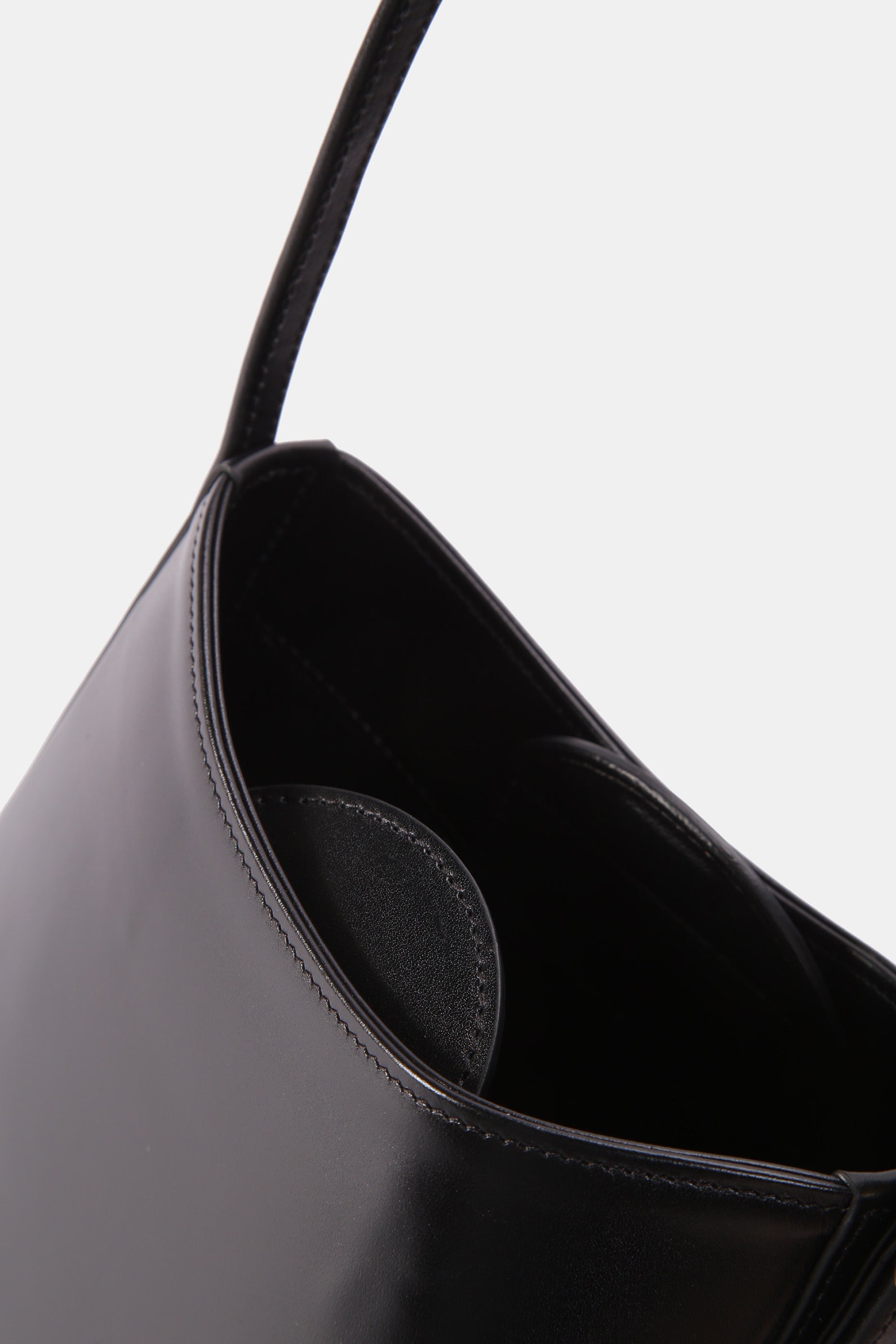 Poelle Atelier luxury minimalist leather bag in black showing smooth leather texture and interior detail