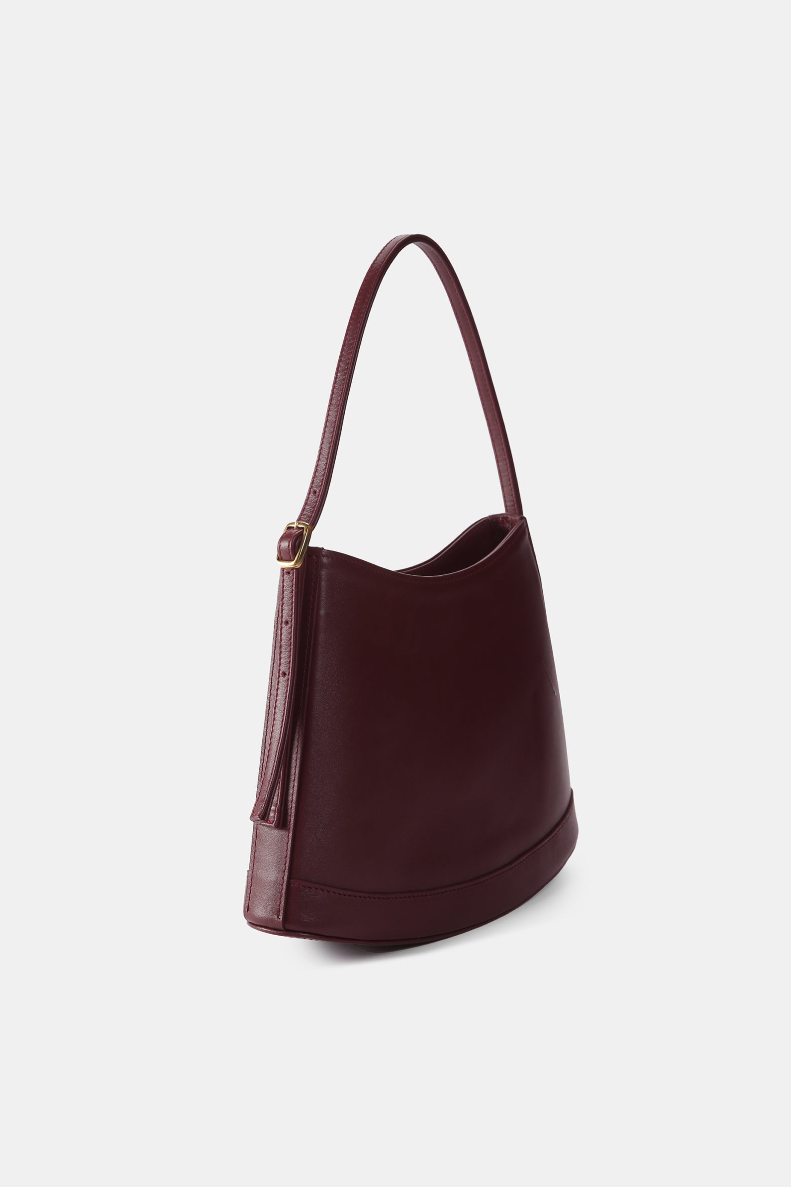 Poelle Atelier luxury minimalist leather bag in deep burgundy with adjustable strap
