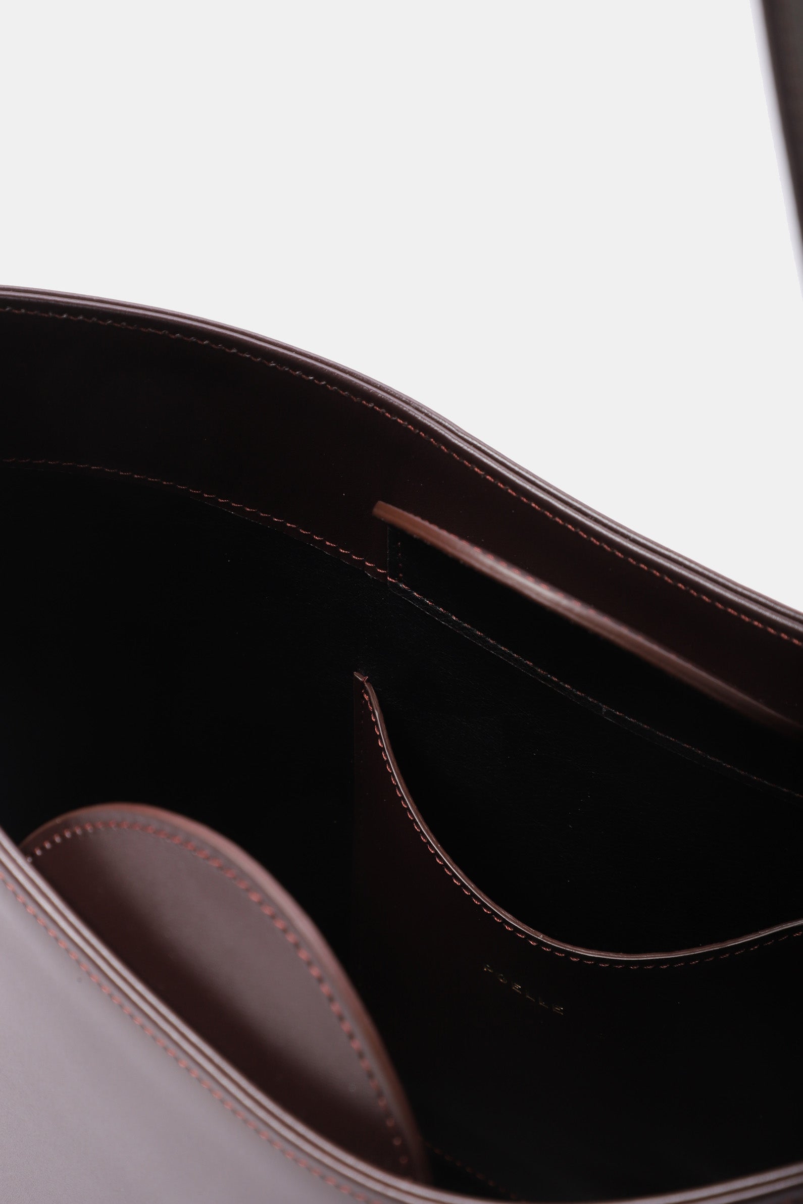 Interior view of Poelle Atelier luxury minimalist sculptural bag showing smooth leather lining and stitching